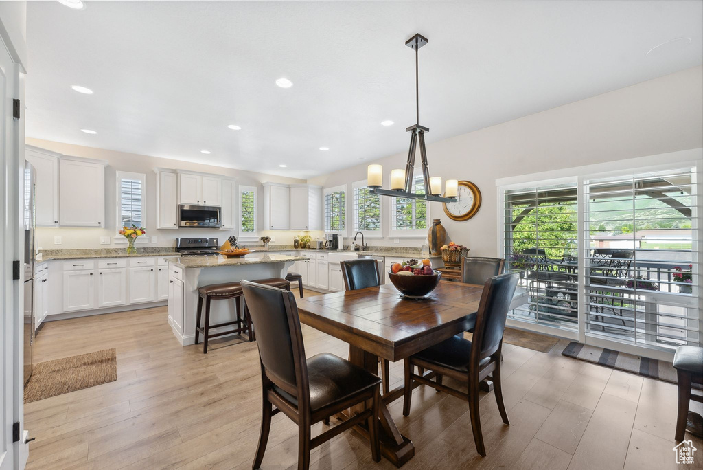 Dining space with an inviting chandelier, sink, and light wood-type flooring