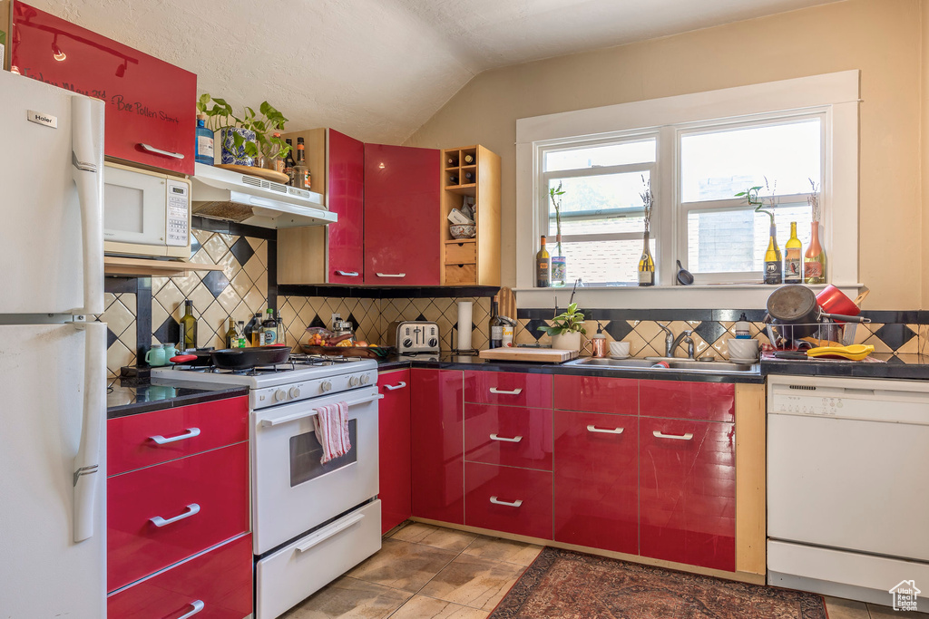 Kitchen with backsplash, sink, and white appliances