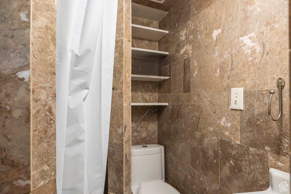 Bathroom featuring curtained shower and toilet