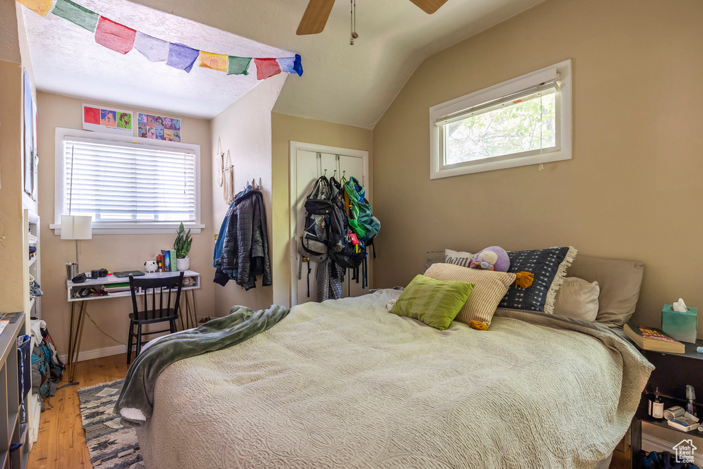 Bedroom featuring a closet, ceiling fan, vaulted ceiling, and hardwood / wood-style floors