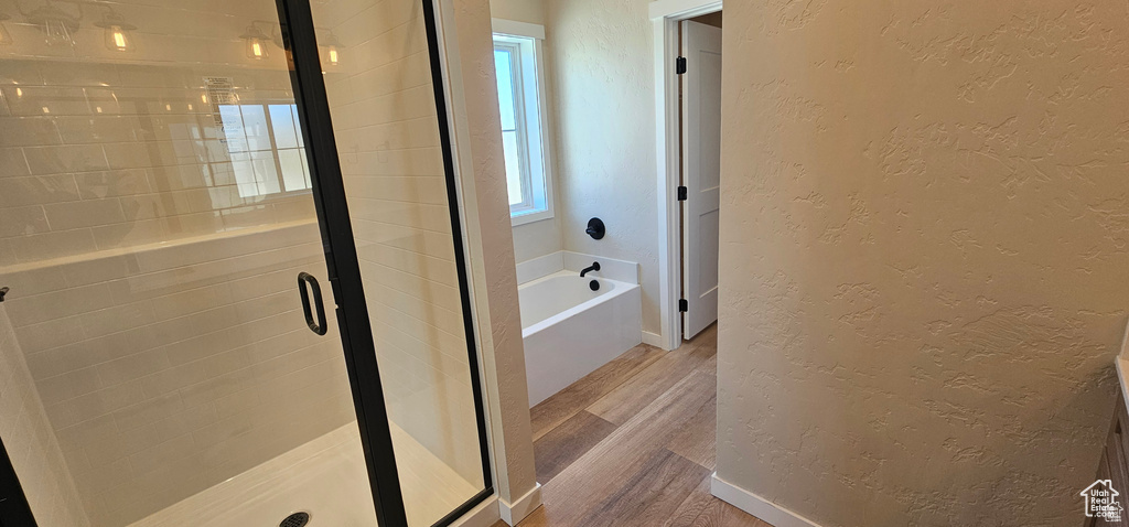 Bathroom featuring hardwood / wood-style floors and separate shower and tub