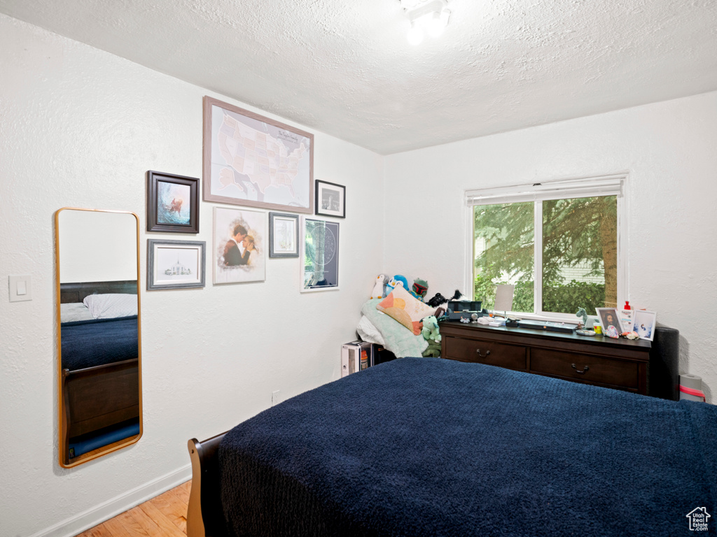 Bedroom featuring a textured ceiling and light wood-type flooring