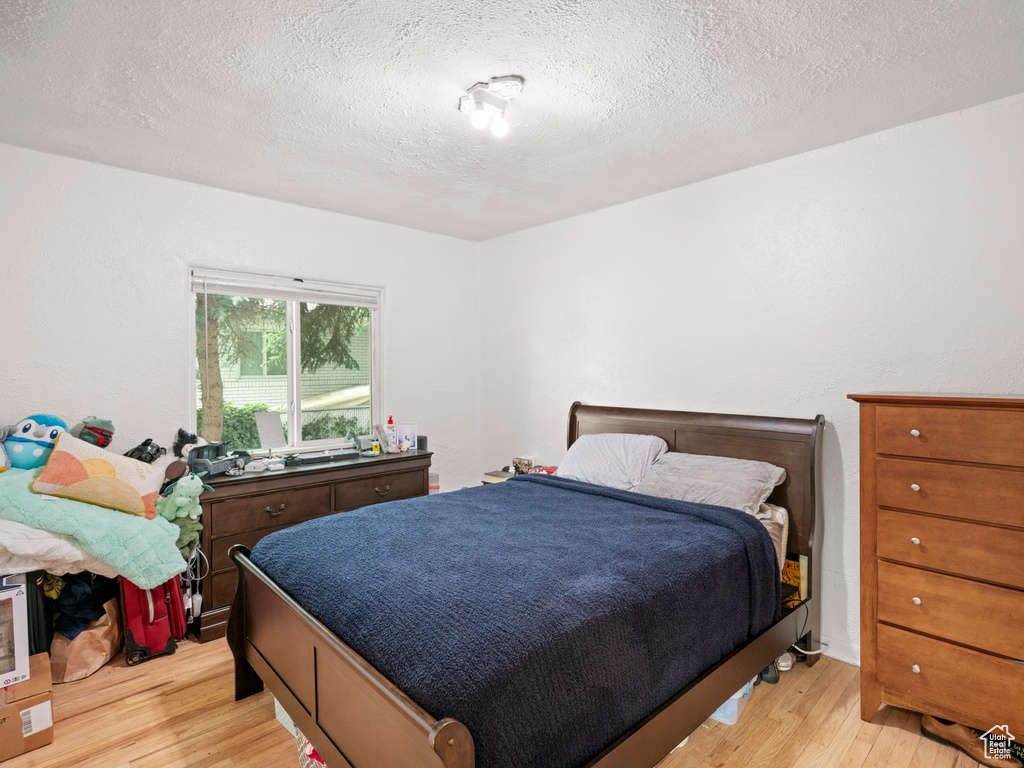 Bedroom featuring light hardwood / wood-style floors and a textured ceiling