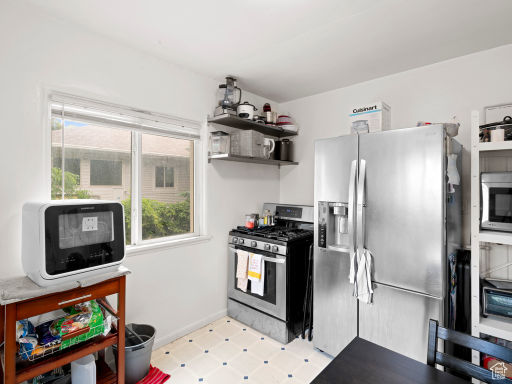 Kitchen with stainless steel appliances and light tile floors