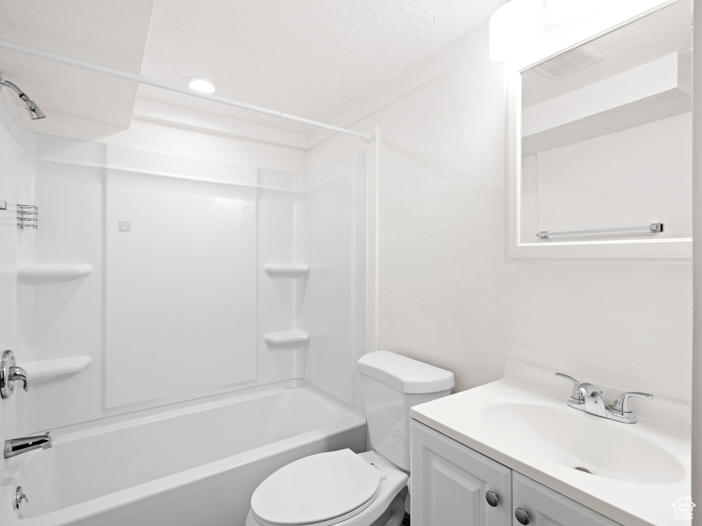 Full bathroom featuring vanity with extensive cabinet space, toilet, and bathtub / shower combination