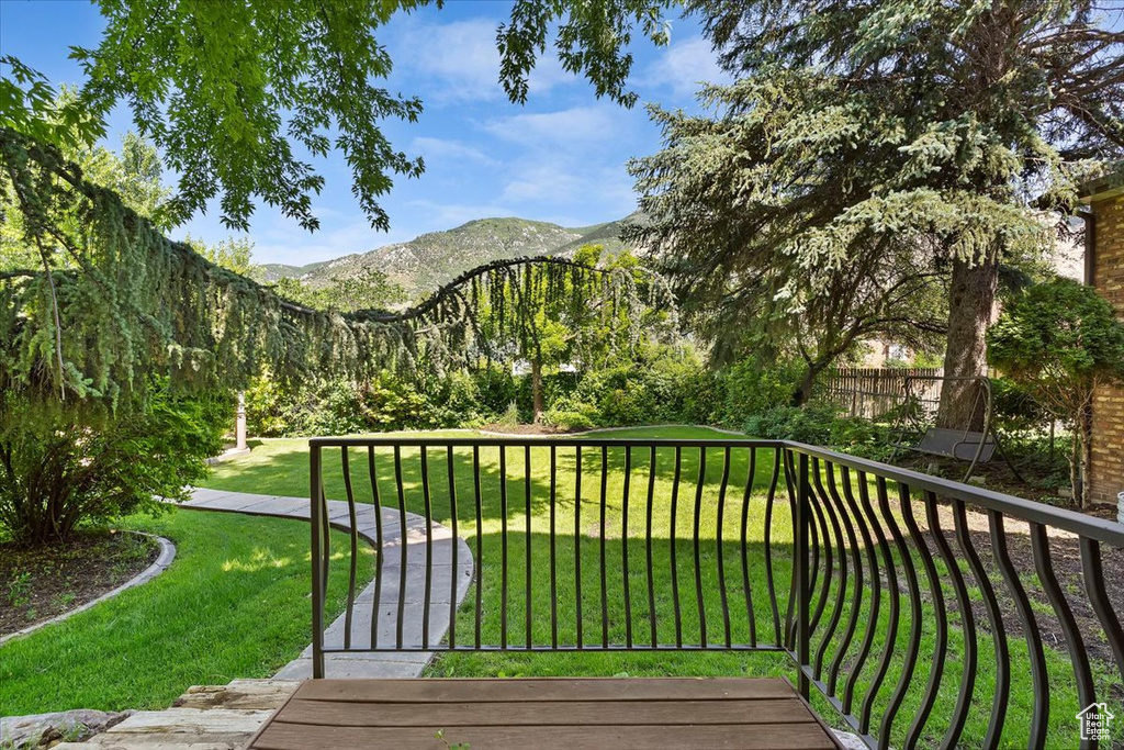 Wooden deck with a yard and a mountain view