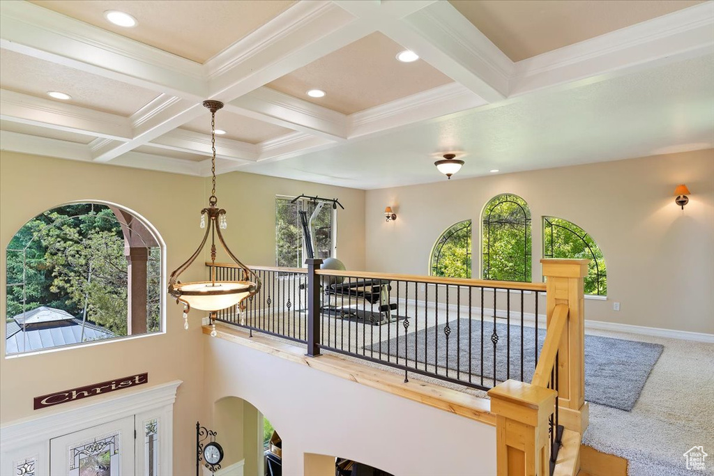 Hallway with a wealth of natural light, coffered ceiling, and beam ceiling