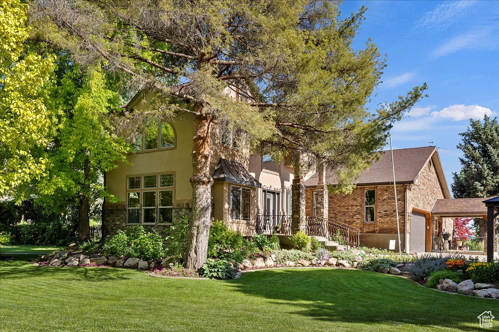 View of front of property featuring a garage and a front yard