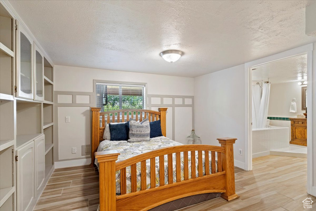 Bedroom with connected bathroom and a textured ceiling