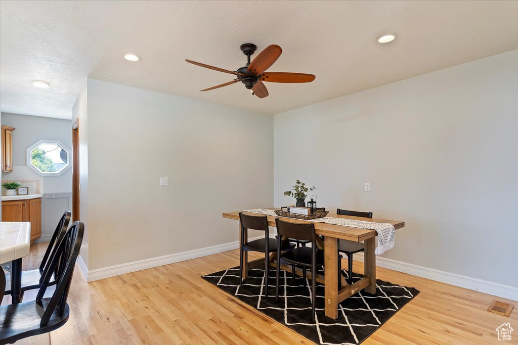 Dining area with light hardwood / wood-style floors and ceiling fan