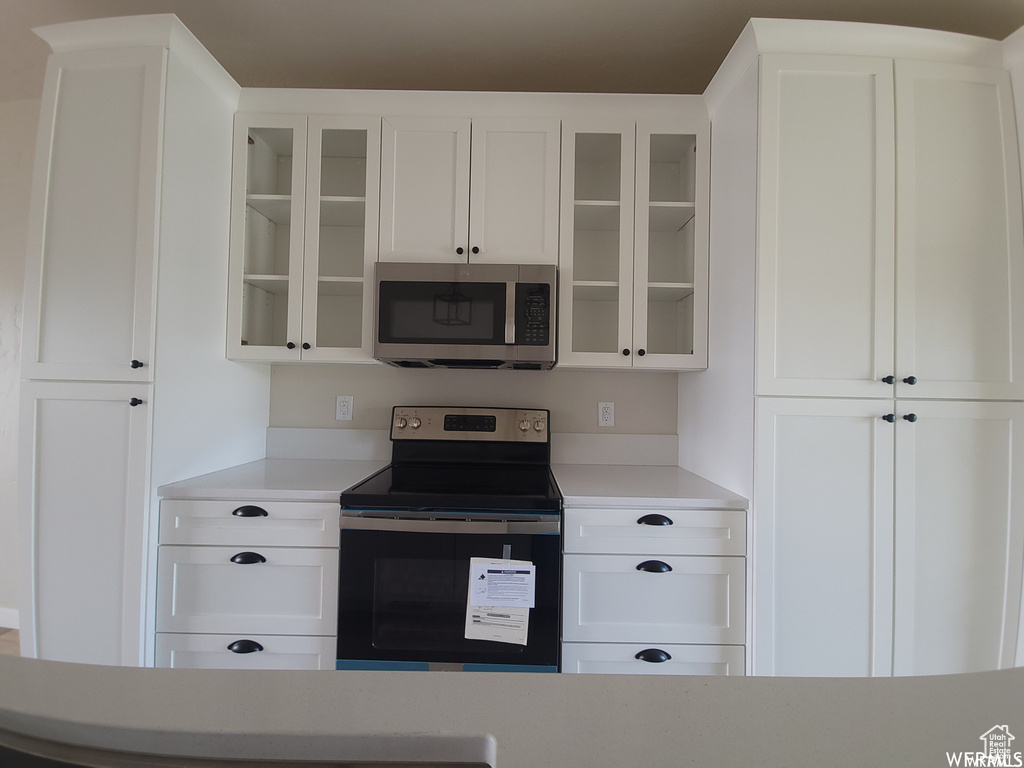 Kitchen featuring stainless steel appliances and white cabinetry