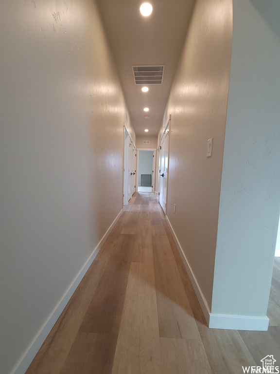 Corridor with hardwood / wood-style floors