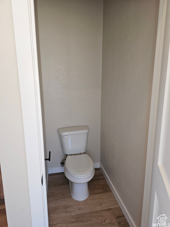 Bathroom with hardwood / wood-style floors and toilet