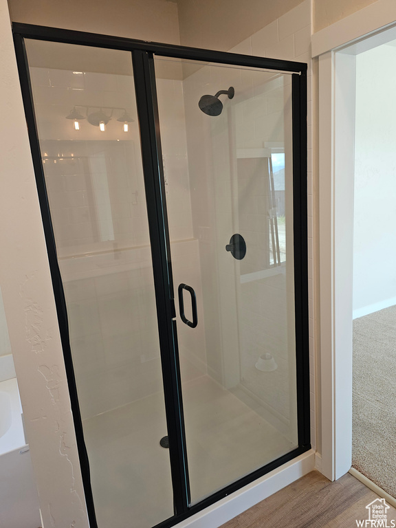 Bathroom featuring hardwood / wood-style floors and independent shower and bath