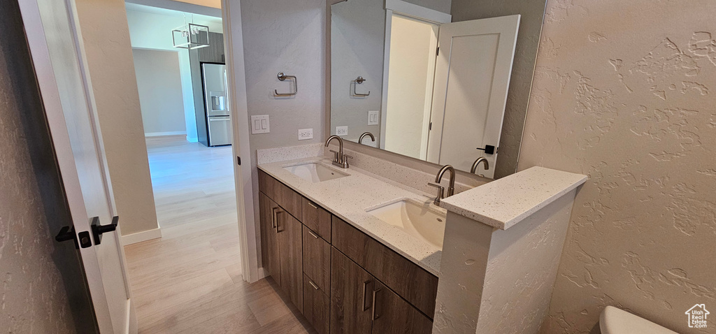 Bathroom with wood-type flooring and dual vanity