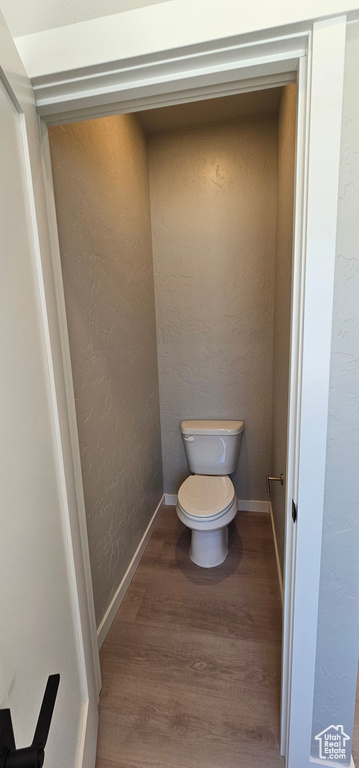 Bathroom with hardwood / wood-style flooring and toilet