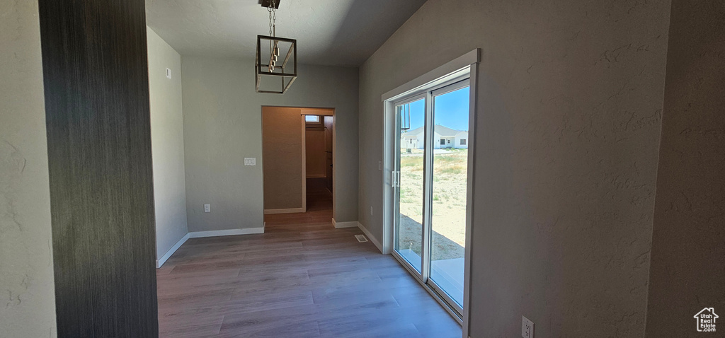 Corridor with light hardwood / wood-style flooring