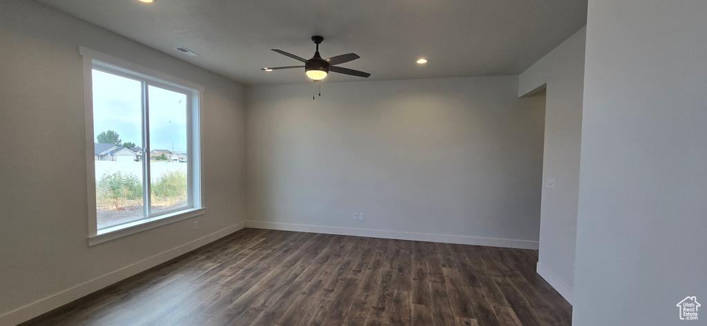 Unfurnished room with dark hardwood / wood-style flooring and ceiling fan