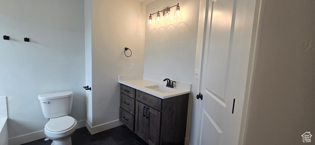 Bathroom featuring toilet, tile patterned floors, and vanity