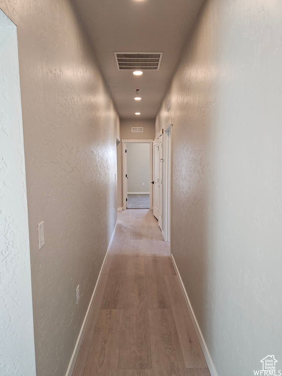 Corridor with light hardwood / wood-style flooring