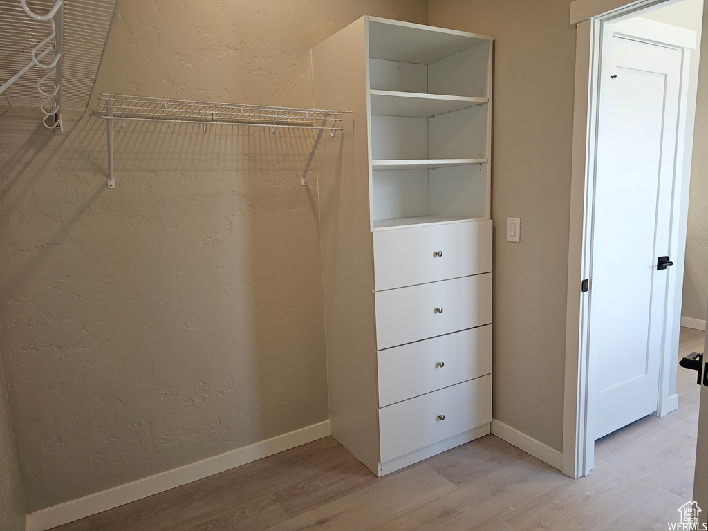 Spacious closet with light hardwood / wood-style floors