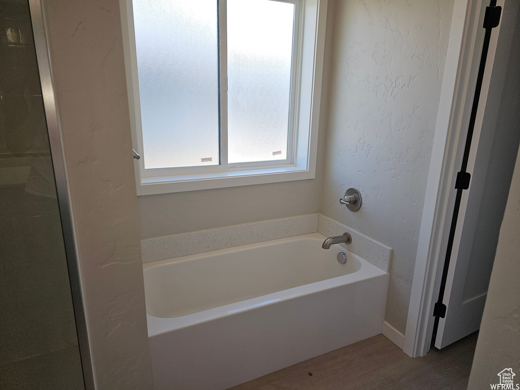 Bathroom featuring hardwood / wood-style flooring and a bathing tub