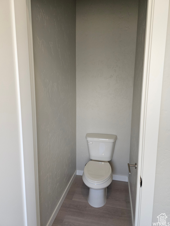 Bathroom with hardwood / wood-style floors and toilet