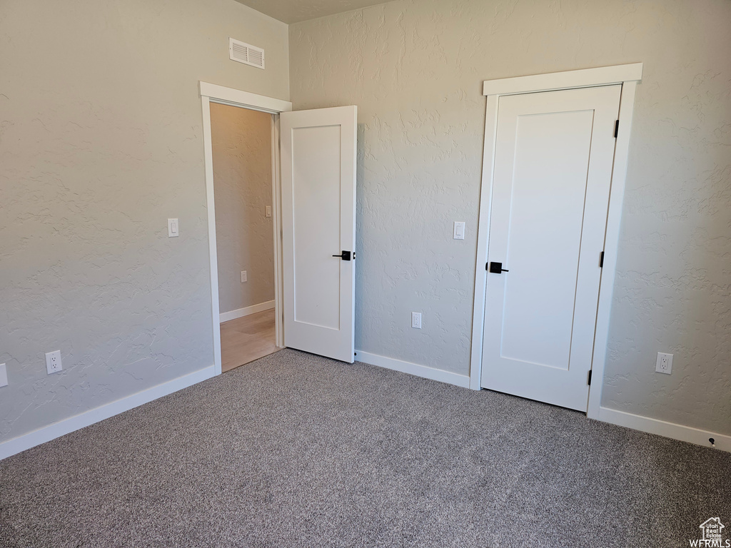 Unfurnished bedroom with carpet