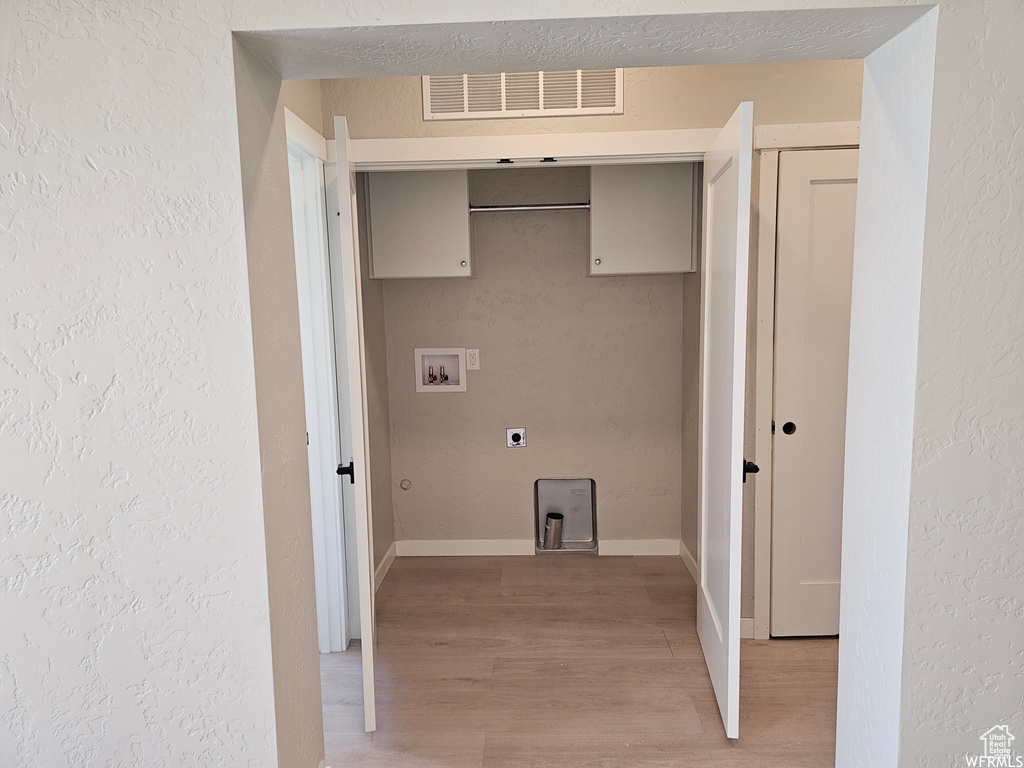 Laundry room featuring electric dryer hookup, hardwood / wood-style floors, a textured ceiling, and hookup for a washing machine