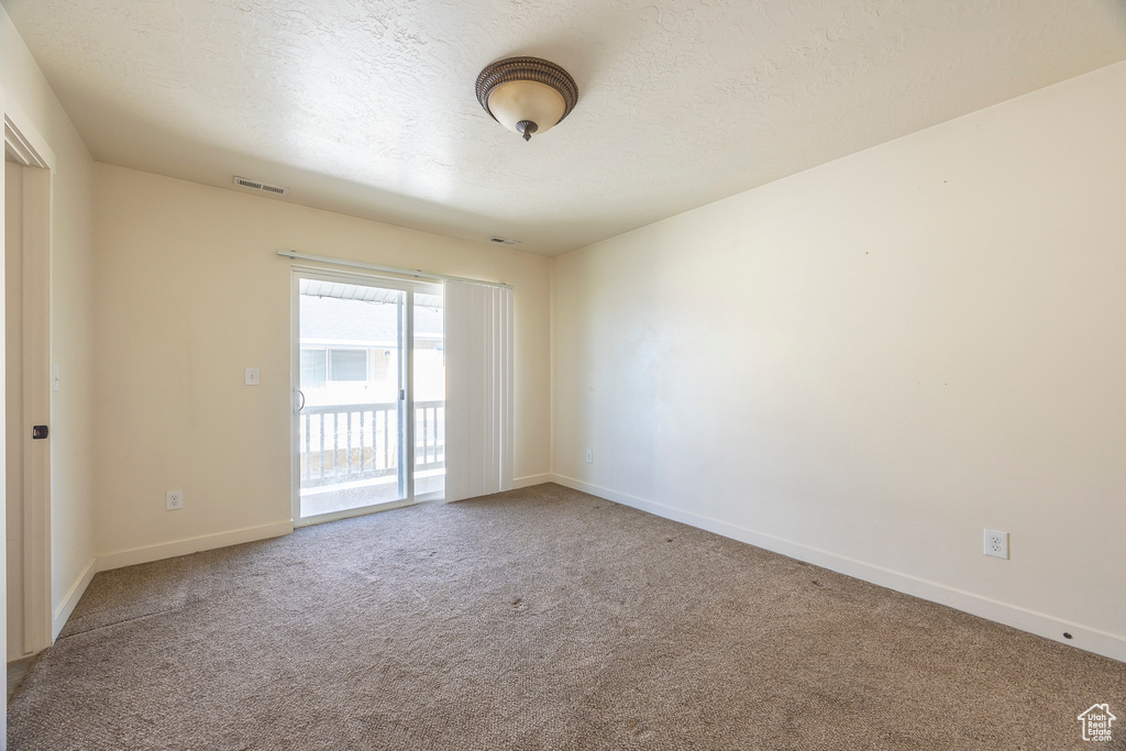 Carpeted empty room with a textured ceiling