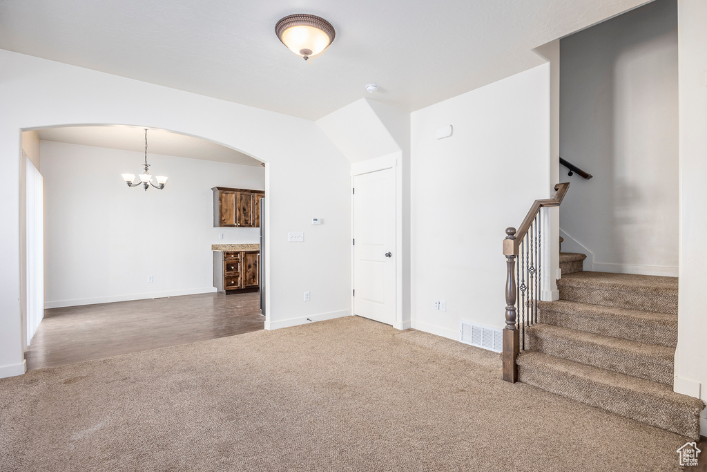 Unfurnished living room featuring a chandelier and hardwood / wood-style flooring