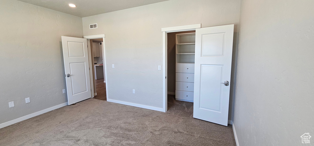 Unfurnished bedroom with a closet and carpet floors