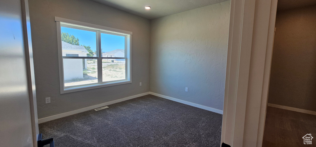 Unfurnished room featuring dark carpet