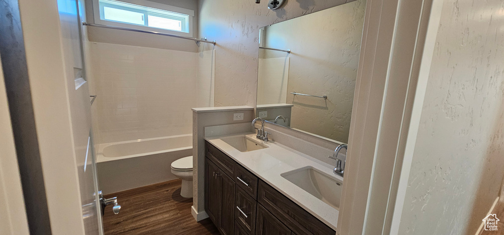 Full bathroom with shower / bath combination, toilet, wood-type flooring, and dual bowl vanity