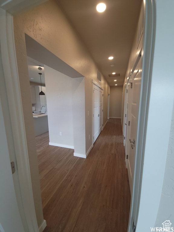 Hallway with dark hardwood / wood-style flooring