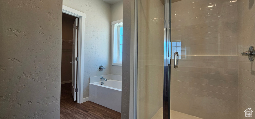 Bathroom featuring shower with separate bathtub and hardwood / wood-style flooring