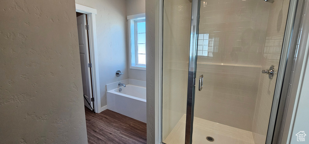 Bathroom with hardwood / wood-style flooring and independent shower and bath