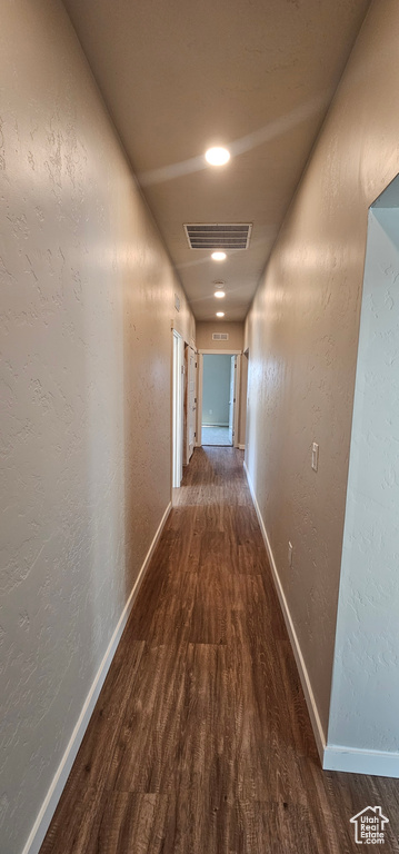 Corridor with dark hardwood / wood-style flooring