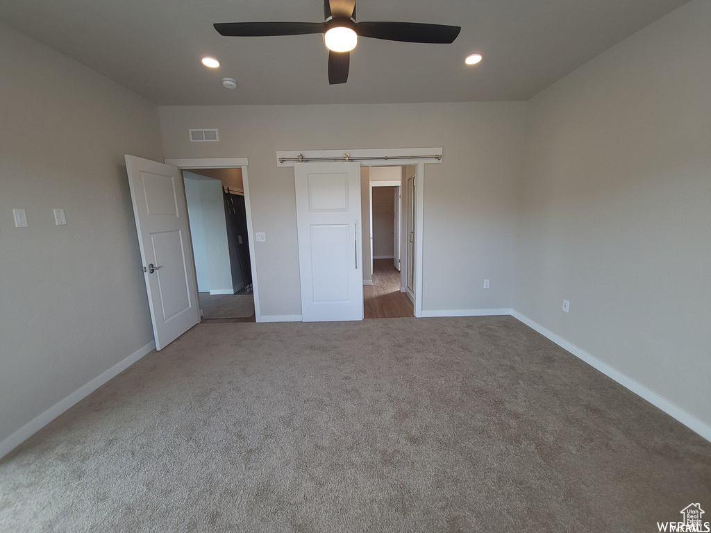 Unfurnished bedroom with carpet flooring and ceiling fan