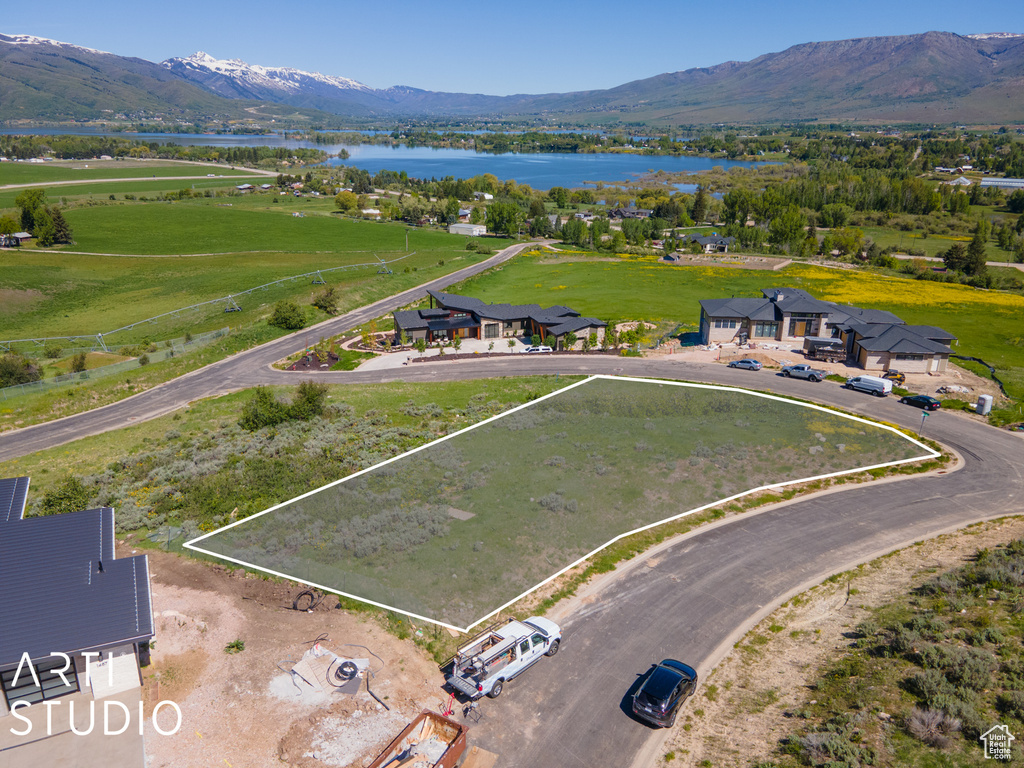Drone / aerial view featuring a water and mountain view
