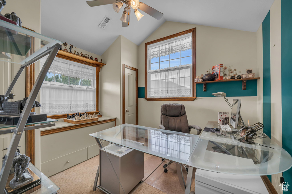 Carpeted home office with lofted ceiling and ceiling fan