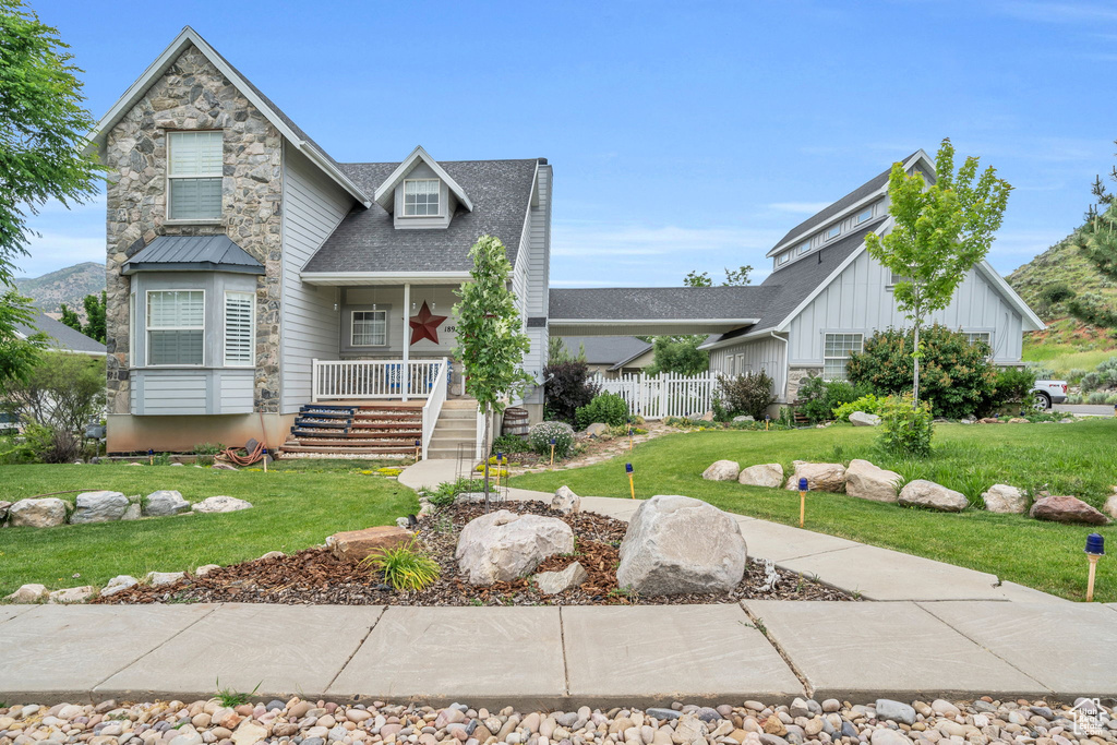 View of front of house with a porch and a front lawn