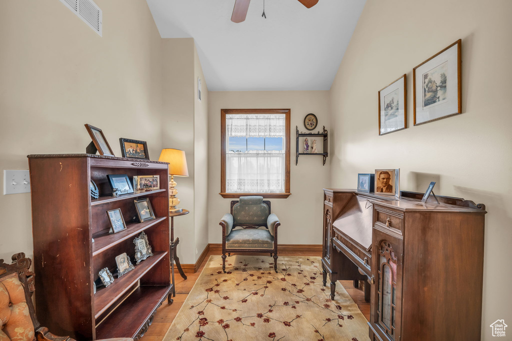 Living area with vaulted ceiling, ceiling fan, and light hardwood / wood-style flooring