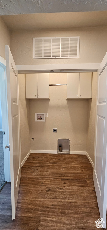 Washroom with washer hookup, hookup for an electric dryer, cabinets, and dark wood-type flooring