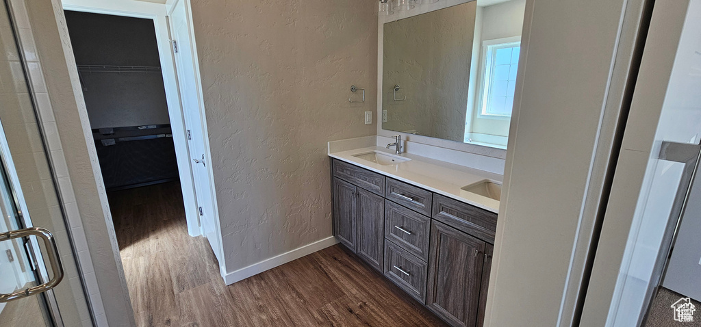 Bathroom with an enclosed shower, dual bowl vanity, and hardwood / wood-style floors