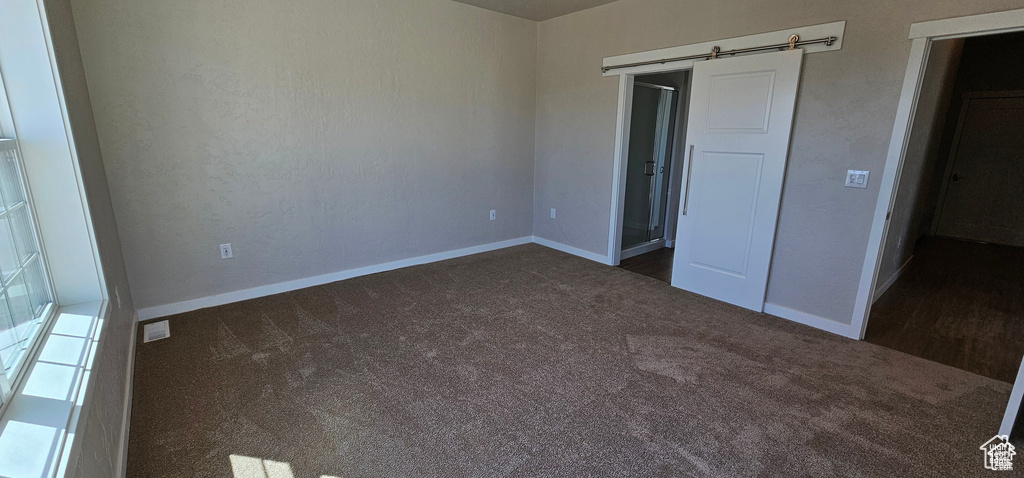 Unfurnished bedroom featuring dark colored carpet