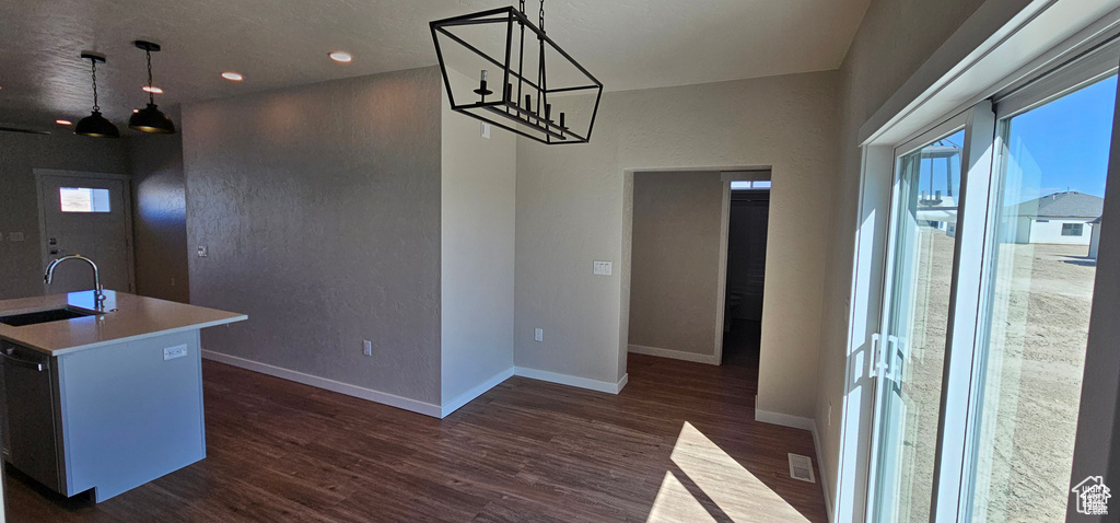 Dining room featuring dark wood-type flooring, sink, and a chandelier