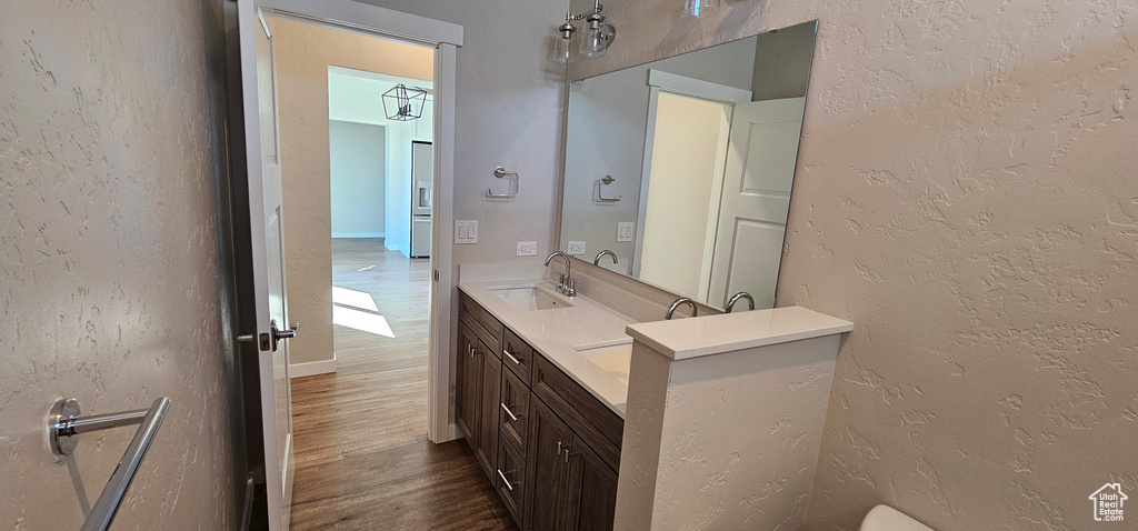 Bathroom with double vanity and hardwood / wood-style floors