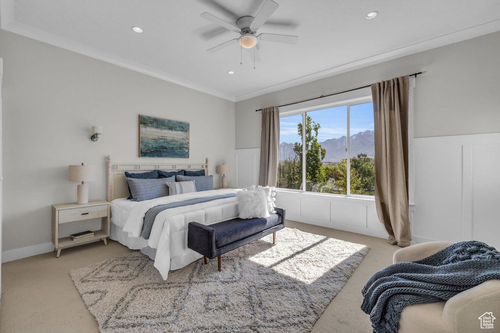 Carpeted bedroom featuring ceiling fan and crown molding