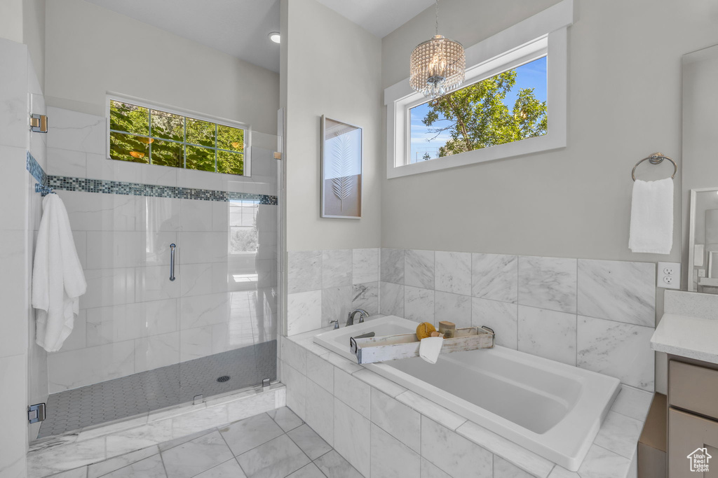 Bathroom with a chandelier, plus walk in shower, plenty of natural light, and vanity